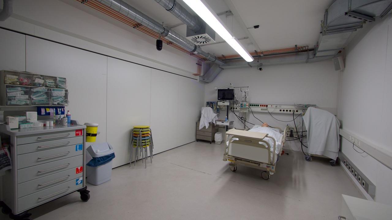 Intensivzimmer: ein Patientenbett mit Puppe; sieben Hocker; ein Narkosewagen; Trennwand geschlossen
 © 